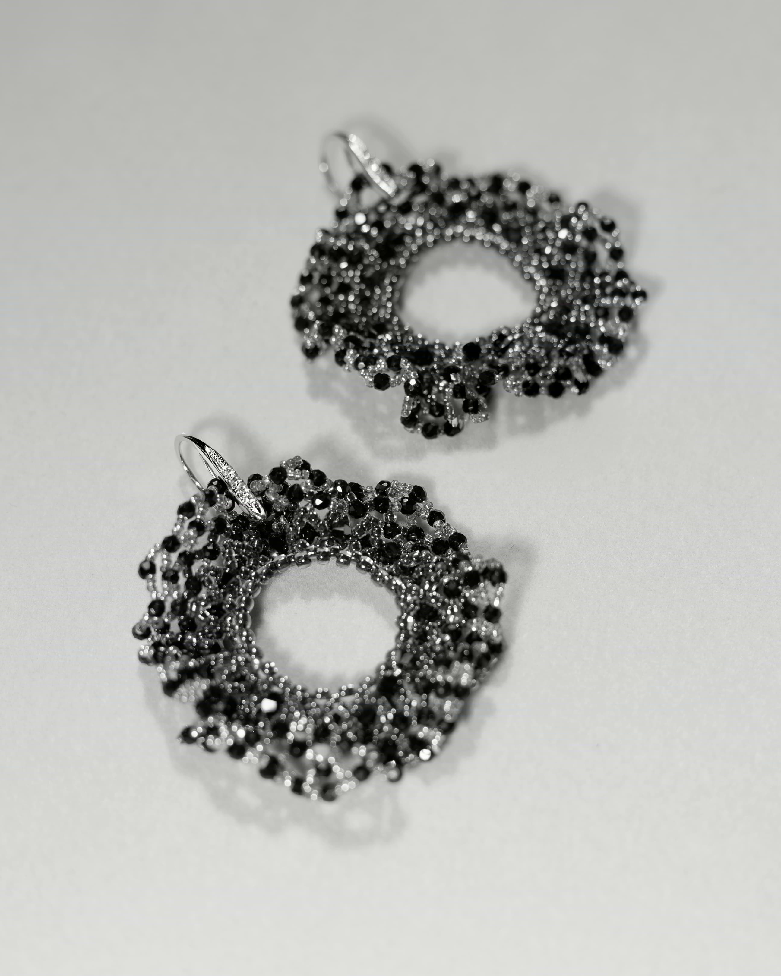 Pair of black and silver earrings on a light gray background