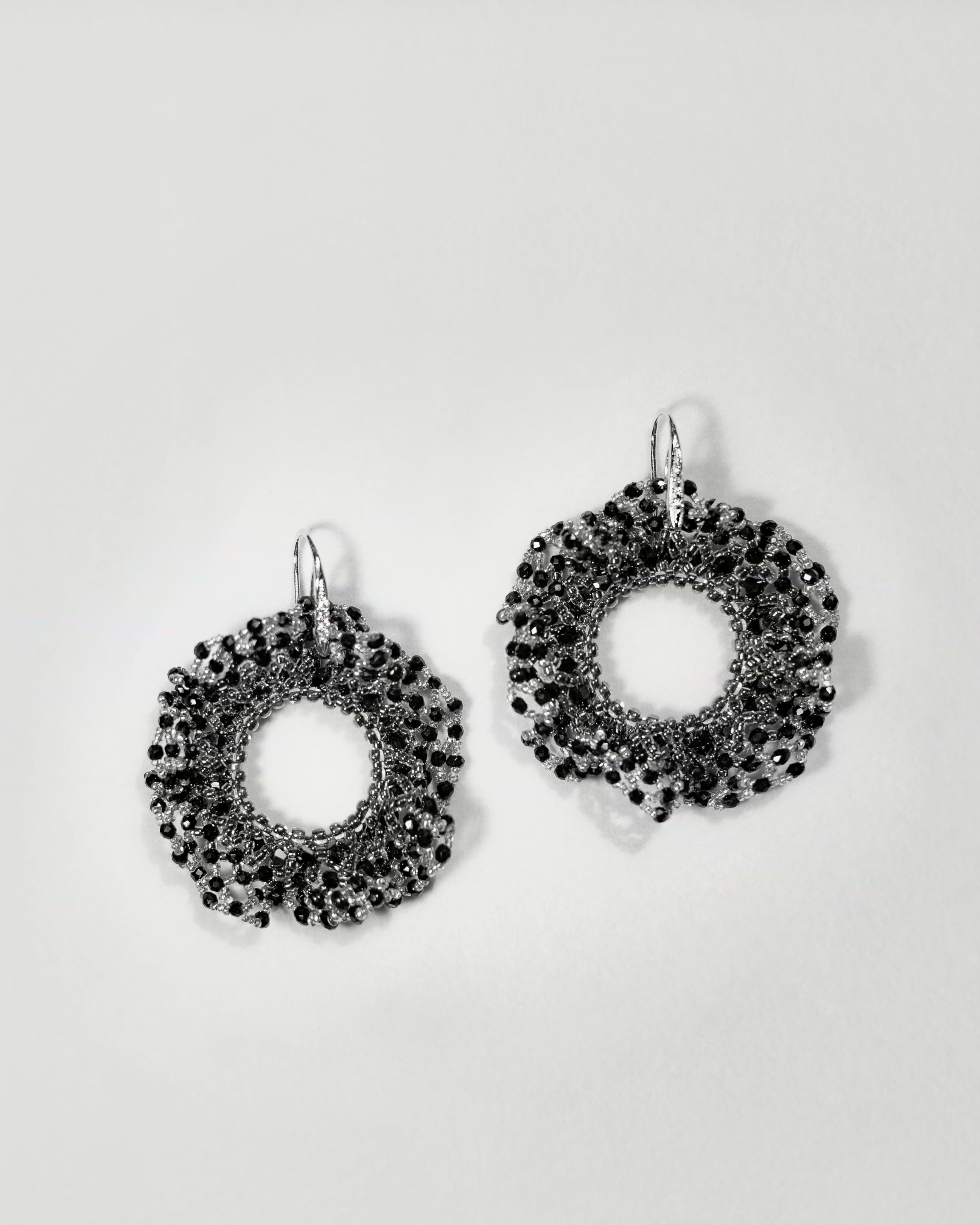Pair of black beaded earrings on a light gray background