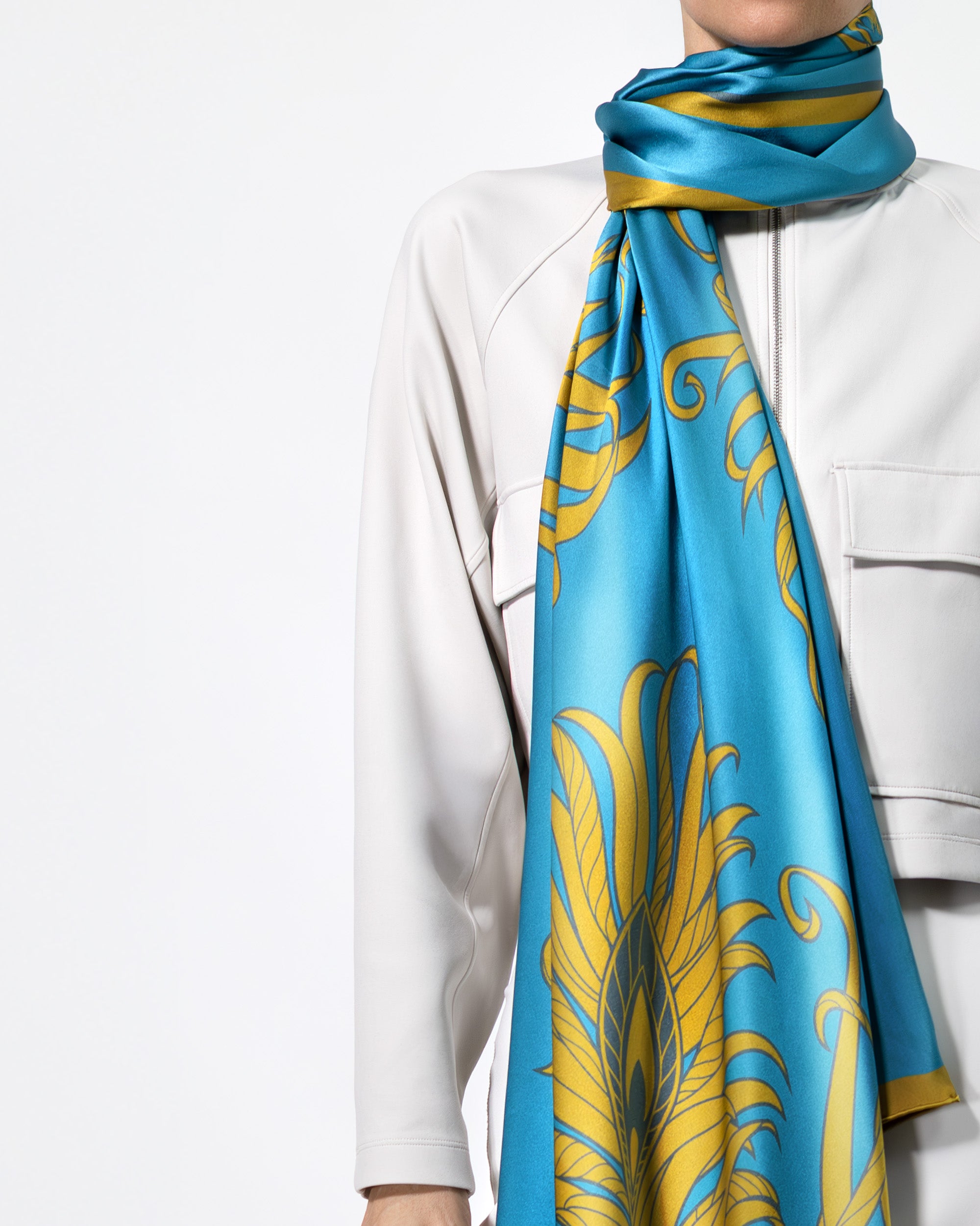 Person wearing a blue and gold patterned scarf on a white background